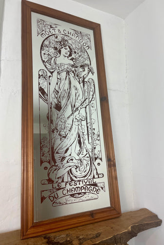 Gorgeous vibrant art nouveau mirror showing stunning intricate designs featuring a beautiful lady with a floral pattern background with a stand-on designer branding with the famous champagne maker