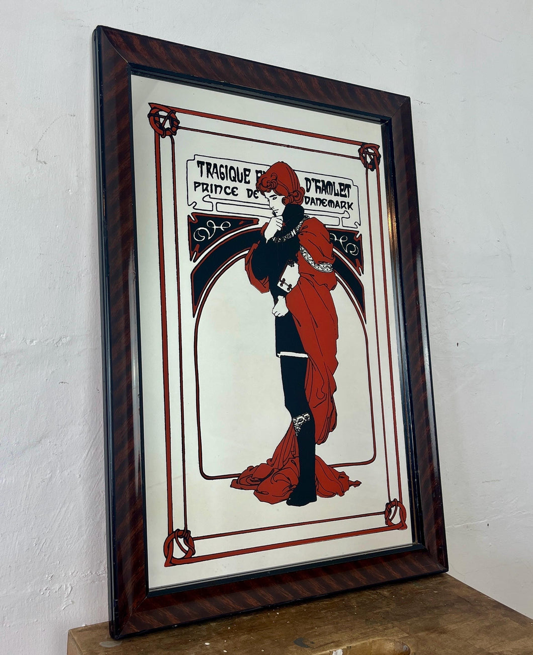 Stunning Mucha mirror featuring vibrant tones featuring a large detailed picture of the figure in orange and black with an intricate pattern border following with the same colours and bold vivid fonts to create a stand out design.