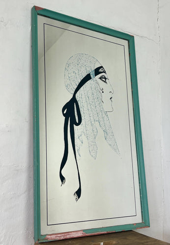 A collectible advertising piece featuring a glamorous lady in a vintage-style scarf bandana with her ribbon flowing down, posing thoughtfully. The mirror has a stylish feel and a noir finish with hint if colour. It is an excellent wall art piece to add a nice touch to your home.