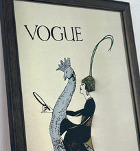 Load image into Gallery viewer, This exquisite vintage item showcases a captivating peacock design that draws inspiration from Vogue&#39;s April 1918 magazine cover. It depicts a sophisticated lady adorned with a fashionable headband, holding a mirror above the Vogue designer logo, all encased within a delicate border.
