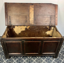 Load image into Gallery viewer, The antique oak coffer is of simple, plain form and has a hinged lid that opens to reveal a spacious interior. The coffer has a three-panel front and is raised on block feet. One of my favourite parts is the back panel that has been crudely chiselled from one section of oak, with an excellent, authentic craftsmanship finish.
