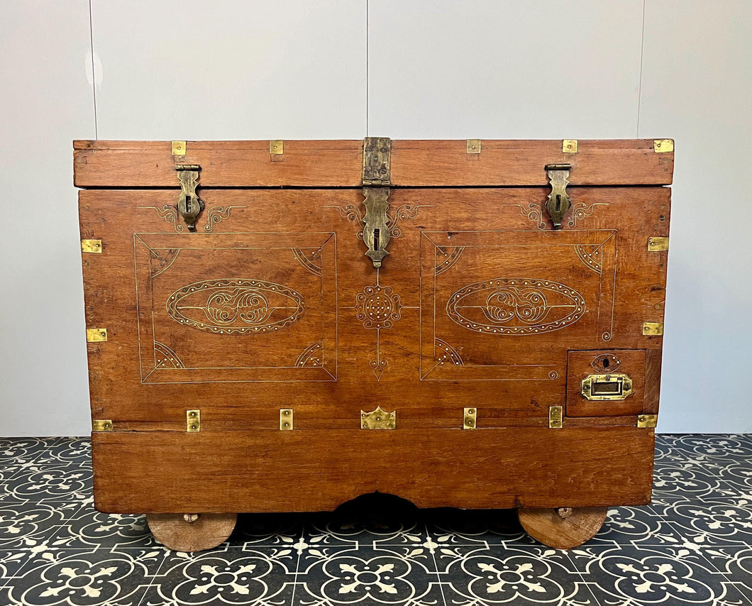 A beautiful Anglo-Indian Marriage Dowry chest circa 1900 with campaign handles and original wooden wheels, a very well-crafted and decorative chest, decorated with brass inlaid wire work, classically indicative of Indian artistry. This piece is a fine example of an Anglo-Indian chest. Designed as a dowry piece to be given by the father of the bride in an Indian wedding, you would have gold, jewellery, land deeds, money and fine linens stored inside.