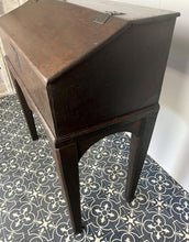 Load image into Gallery viewer, Constructed from rich dark oak, it features a plain, authentic craftsmanship design supported by chunky tapered legs. The hinged lid features excellent dark iron pads with a striking bolt finish. The interior includes a drawer panel that opens to reveal two hidden drawers that slide across, adding a touch of period charm
