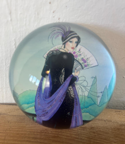Vintage Art Deco style glass paperweight featuring an illustration of a woman, often referred to as a "flapper lady" or "Gatsby lady" due to the 1920s aesthetic.