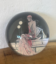 Load image into Gallery viewer, Beautiful vintage glass paperweight in Art Deco style, featuring an illustration of a lady in a pink dress and headpiece. This particular style, often associated with the roaring twenties, is characterised by its elegant and sophisticated portrayal of women, usually referred to as flapper ladies or Gatsby ladies.
