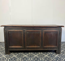 Load image into Gallery viewer, The antique oak coffer is of simple, plain form and has a hinged lid that opens to reveal a spacious interior. The coffer has a three-panel front and is raised on block feet. One of my favourite parts is the back panel that has been crudely chiselled from one section of oak, with an excellent, authentic craftsmanship finish.
