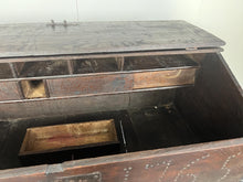 Load image into Gallery viewer, Constructed from rich dark oak, it features a plain, authentic craftsmanship design supported by chunky tapered legs. The hinged lid features excellent dark iron pads with a striking bolt finish. The interior includes a drawer panel that opens to reveal two hidden drawers that slide across, adding a touch of period charm
