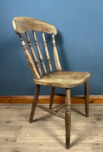 Load image into Gallery viewer, This style is a type of Windsor chair, a design that originated in England in the early 18th century and is characterised by its solid wooden seat into which the legs and spindles of the back are inserted.
