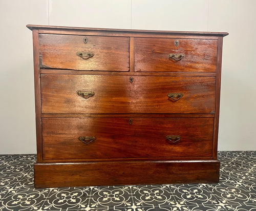 An immaculate quality Arts & Crafts chest of drawers made in figured English mahogany. Having an arrangement of 2 over 2 drawers, all retaining the original decorative handles and escutcheons. With mahogany sides on a plinth. Beautiful original condition throughout. English, Circa 1900.