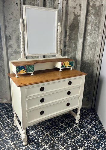 Beautiful vintage shabby chic dressing table with a stylish mirror and sleek drawers. This piece features a painted finish country cream with a contrasting natural wooden top, its distinctive floral patterned drawer fronts add a unique touch.