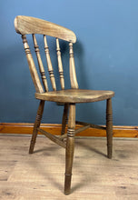 Load image into Gallery viewer, This style is a type of Windsor chair, a design that originated in England in the early 18th century and is characterised by its solid wooden seat into which the legs and spindles of the back are inserted.
