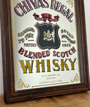 Load image into Gallery viewer, The mirror features vibrant, bold fonts in fabulous colours, with the royal crest in the middle and an intricate golden border. It is presented in a wooden frame and is in vintage condition, with a few signs of authentic patina.
