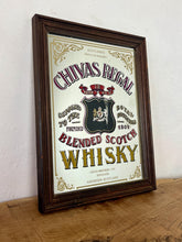 Load image into Gallery viewer, The mirror features vibrant, bold fonts in fabulous colours, with the royal crest in the middle and an intricate golden border. It is presented in a wooden frame and is in vintage condition, with a few signs of authentic patina.
