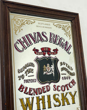 Load image into Gallery viewer, The mirror features vibrant, bold fonts in fabulous colours, with the royal crest in the middle and an intricate golden border. It is presented in a wooden frame and is in vintage condition, with a few signs of authentic patina.
