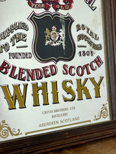 Load image into Gallery viewer, The mirror features vibrant, bold fonts in fabulous colours, with the royal crest in the middle and an intricate golden border. It is presented in a wooden frame and is in vintage condition, with a few signs of authentic patina.
