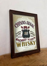 Load image into Gallery viewer, The mirror features vibrant, bold fonts in fabulous colours, with the royal crest in the middle and an intricate golden border. It is presented in a wooden frame and is in vintage condition, with a few signs of authentic patina.
