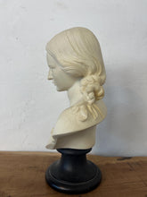 Load image into Gallery viewer, The figure depicts a young woman with wavy hair gathered into ringlets over her shoulders, wearing a draped garment with spaghetti straps and rosette detailing. Her facial expression is serene with downcast eyes.
