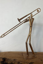 Load image into Gallery viewer, It features abstract, elongated figures of musicians playing various instruments, including a guitar, double bass, trumpet, trombone, saxophone, piano, and drums.
