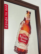 Load image into Gallery viewer, The main image is a unique graphic of an ice-encrusted Estrella Damm bottle held like a popsicle or ice lolly by a hand.
