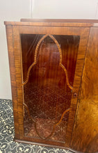 Load image into Gallery viewer, This beautiful piece is a 1930s English Art Deco cocktail cabinet, characterized by its figured walnut veneers and distinctive geometric glazed doors.
