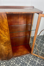 Load image into Gallery viewer, This beautiful piece is a 1930s English Art Deco cocktail cabinet, characterized by its figured walnut veneers and distinctive geometric glazed doors.
