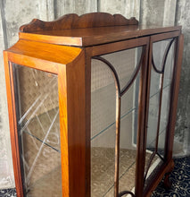 Load image into Gallery viewer, This stunning piece is an antique Art Deco display cabinet, dating from the 1930s. It is characterised by its walnut or mahogany construction, featuring astragal-glazed doors with a distinctive curved pattern and claw-and-ball feet.
