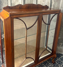 Load image into Gallery viewer, This stunning piece is an antique Art Deco display cabinet, dating from the 1930s. It is characterised by its walnut or mahogany construction, featuring astragal-glazed doors with a distinctive curved pattern and claw-and-ball feet.
