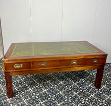 Load image into Gallery viewer, Introducing a unique piece of craftsmanship - a mahogany coffee table in the military campaign style. This stunning table, made in England around the 1950s, features a design that will pique your interest with its formal and executive look.
