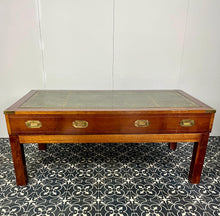 Load image into Gallery viewer, Introducing a unique piece of craftsmanship - a mahogany coffee table in the military campaign style. This stunning table, made in England around the 1950s, features a design that will pique your interest with its formal and executive look.
