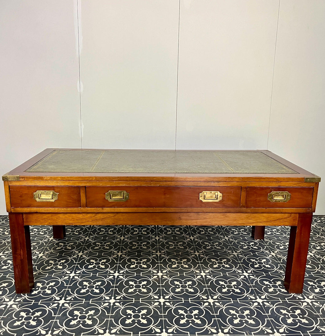 Introducing a unique piece of craftsmanship - a mahogany coffee table in the military campaign style. This stunning table, made in England around the 1950s, features a design that will pique your interest with its formal and executive look.