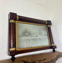 Load image into Gallery viewer, A mid-19th-century rosewood overmantle mirror in landscape form, the frame has classical columns to the sides, and top with gilt collars, and the gilt frame edging has detailed ball feet to create a standout period design.
