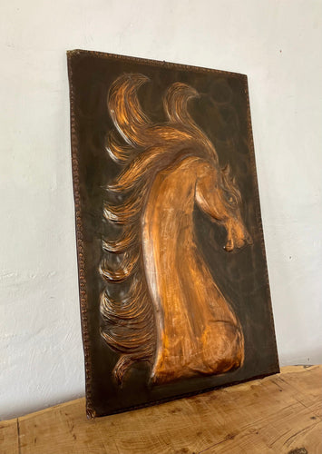Handmade copper horse head plaque. The hose has a long gracious neck and beautiful big eyes. The horse's mane is in the air in an oriol around the horse's head. The horse looks strong.