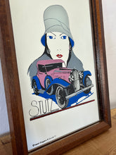 Load image into Gallery viewer, The mirror features vivid tones and a glamorous art deco lady, complemented by bold branding fonts. A vintage classic car in pink and blue colours has a centrepiece.

