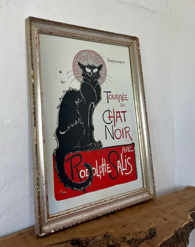 The poster features a black cat with piercing yellow eyes. The cat's silhouette is set against a bold, vibrant background, often in red, black, and yellow shades. Surrounding the cat, there is a flurry of information about the touring shows