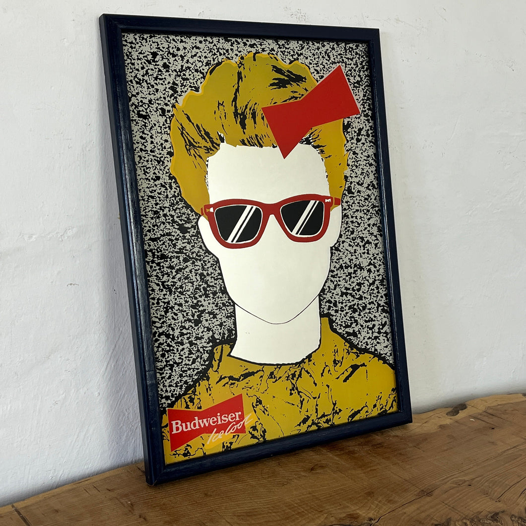 The mirror features a striking design that showcases a fashionable individual with a red bow and sunglasses dressed in a vibrant yellow outfit. Their hair frames the mirror in a TV-like effect for a unique look.