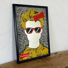 Load image into Gallery viewer, The mirror features a striking design that showcases a fashionable individual with a red bow and sunglasses dressed in a vibrant yellow outfit. Their hair frames the mirror in a TV-like effect for a unique look.
