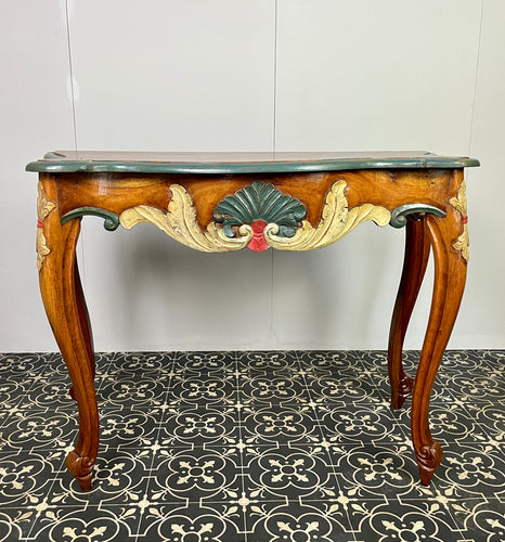 This charming and graceful antique console table has carved and painted sides and legs with a fanned shell and feather design cartouche around the apron and a painted top in carved edging, all in vivid matt tones.