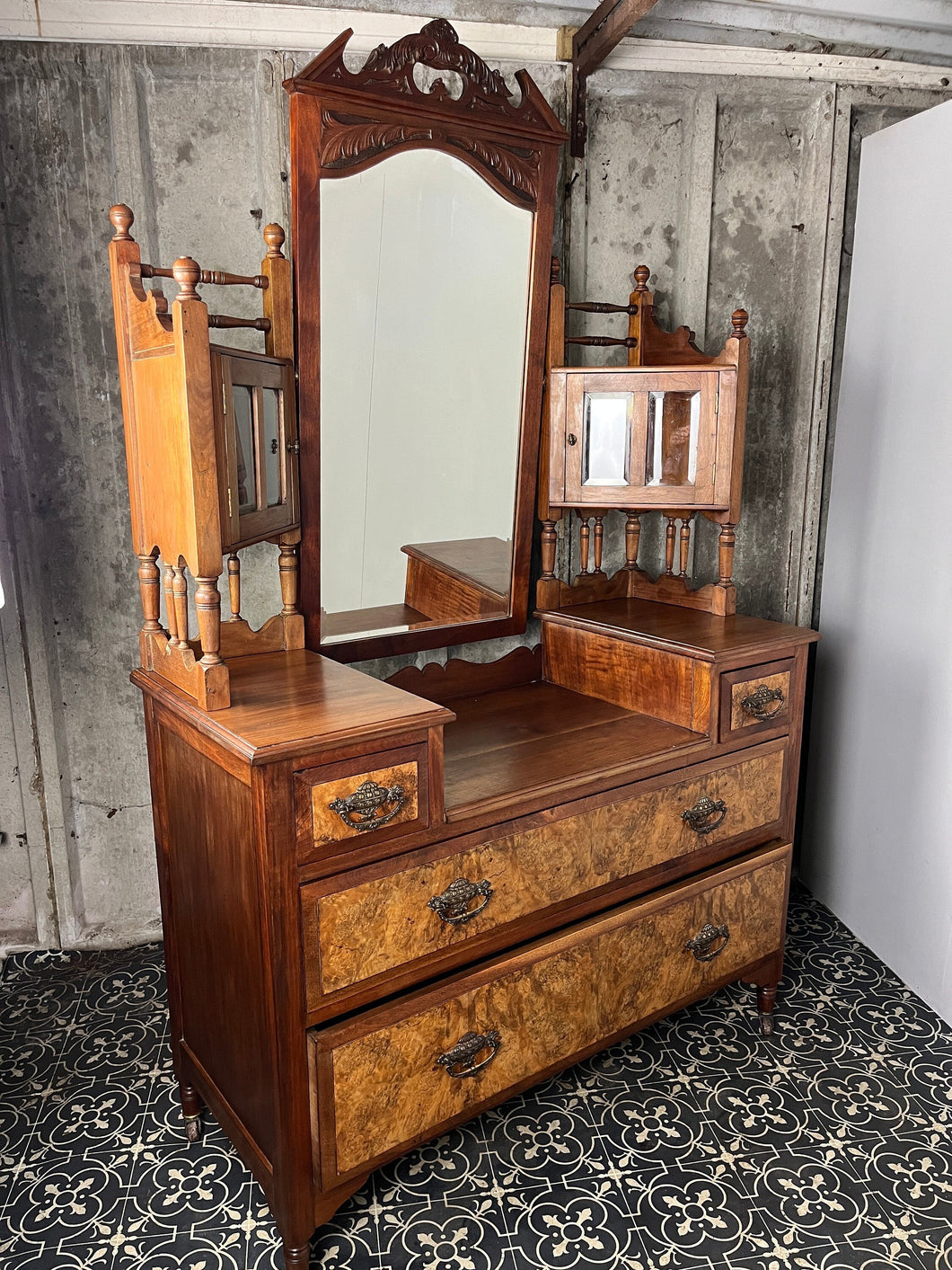 Stunning period antique featuring a long bevelled mirror set within a mahogany frame with expertly shaped, detailed, carved, and added carved pediment to the top.